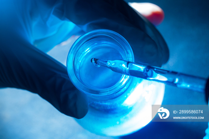 blue science test tube,Flask in scientist hand with drop of chemical liquid in test tube Science and medical research and development concepts.