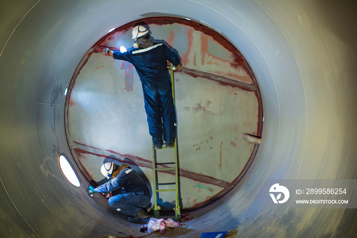 Working male two inspection weld PT test weldment for finding defect  underground of tank equipment tunnel By using the flashlight in side confined