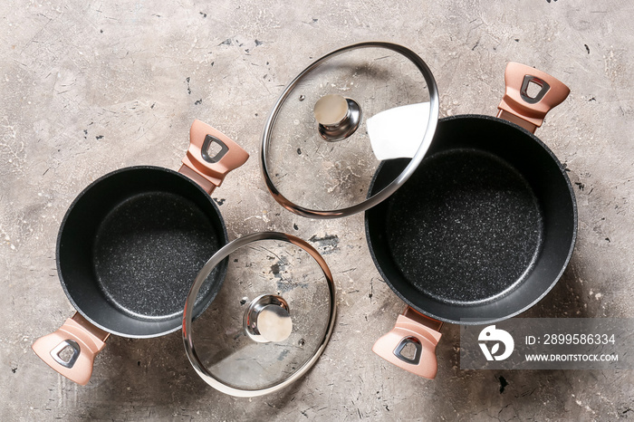 Cooking pots and lids on grunge background