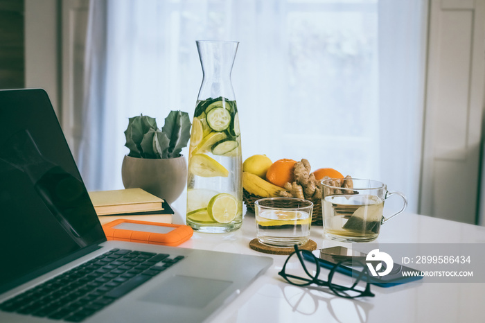 Morning time at home healthy breakfast laptop and phone on table..Natural meal and drink at work in remote office health nutrition food with computer, freelance desktop workspace. Home working concept