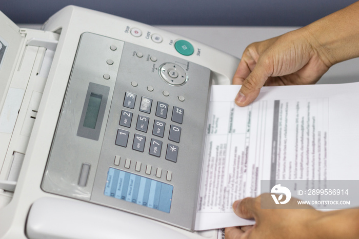 hand man are using a fax machine in the office. Business concept