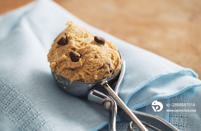 Scoop of edible cookie dough on blue napkin