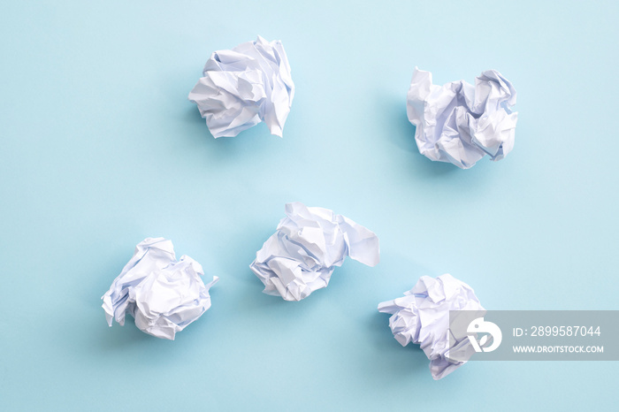 Crumpled paper balls on a blue background