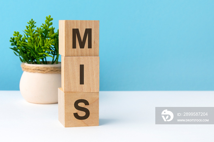 mis - word from wooden blocks with letters, blue background. copy space available