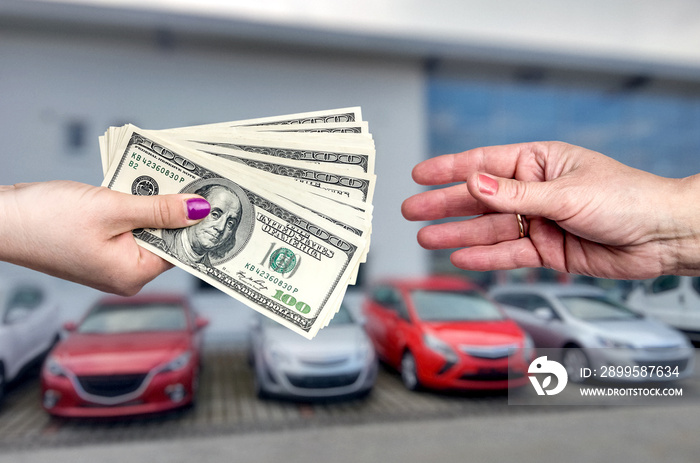 Closeup on hands with dollar, business deal with car