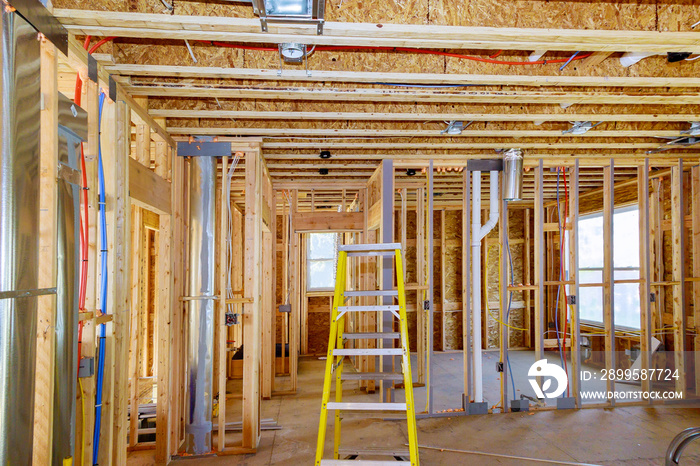 Home construction with hot and cold blue and red pex pipe layout in pipes and exposed beams