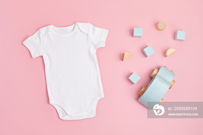 Mockup of white infant bodysuit made of organic cotton with eco friendly baby toys