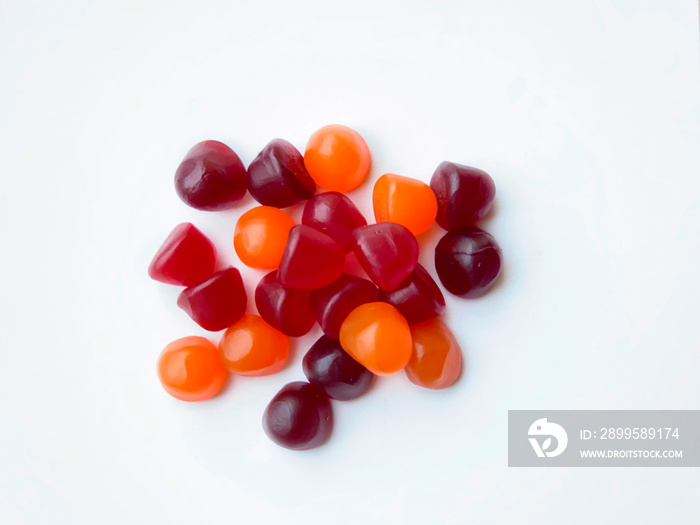 Group of red, orange and purple multivitamin gummies isolated on white background. Healthy lifestyle concept.