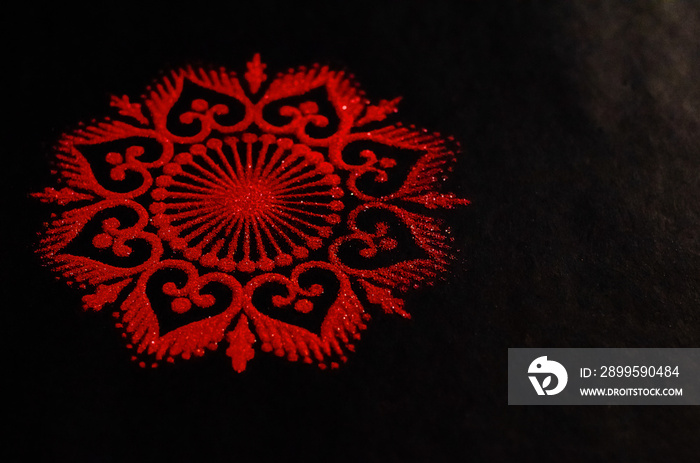 Closeup of a red rangoli art on a black background. diwali concept