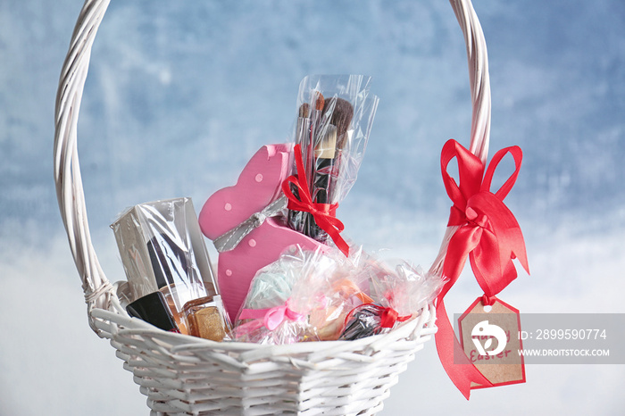 Easter basket with presents and greeting card on blue background