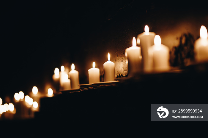 Row of Candles candles on  a dark brick wall