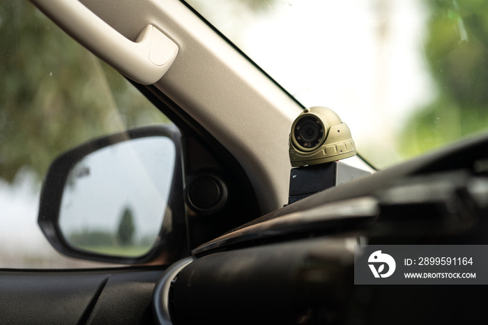 A VDO camera on car console which is installed for safety reason  to monitor the driver and passenger behavior in company vehicle. Transportation and technology equipment photo. Selective focus.