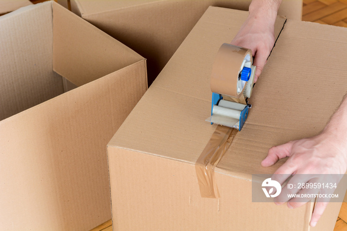 Man sealing a shipping cardboard box