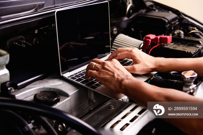 Professional car repair or maintenance mechanic engine working service with laptop computer