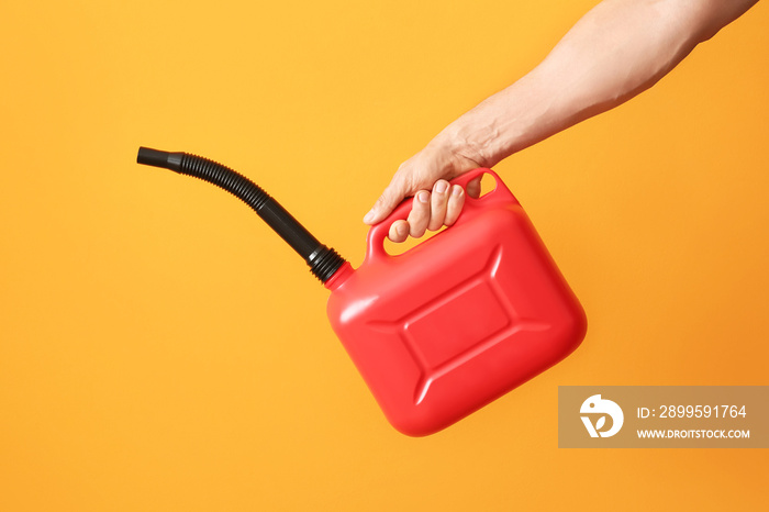 Male hand holding canister with rubber nozzle on color background