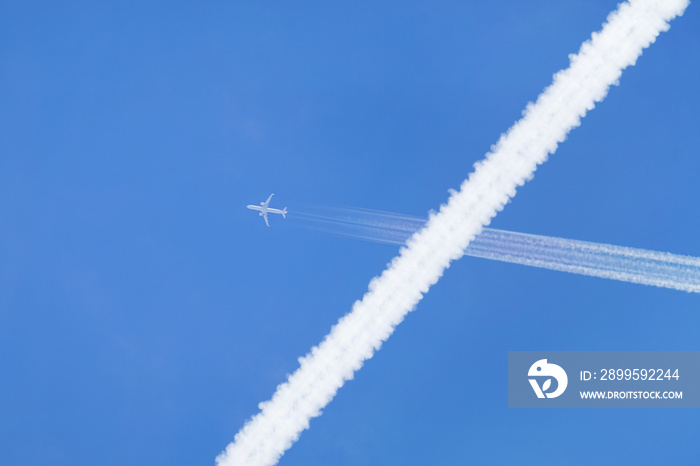 Passenger jet crossed above the recentrly created vapor trail of another jet.