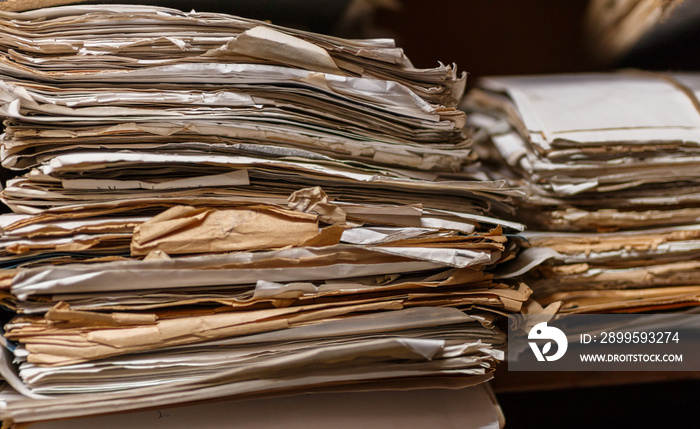 Old dusty stack of papers, files, documents on the shelves of archive room