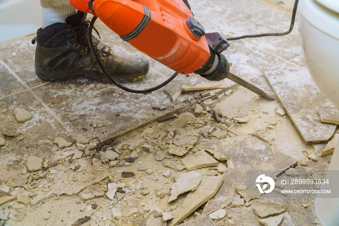 Demolition of old tiles with jackhammer. Renovation of old floor.