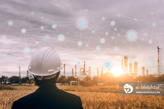 engineering man with safety helmet standing at smart factory background against oil refinery plant in heavy petrochemical industrial estate