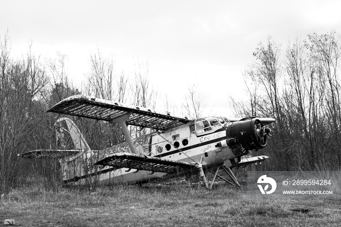 Old destroyed Soviet abandoned military airplanes in the field in Ukraine, black and white