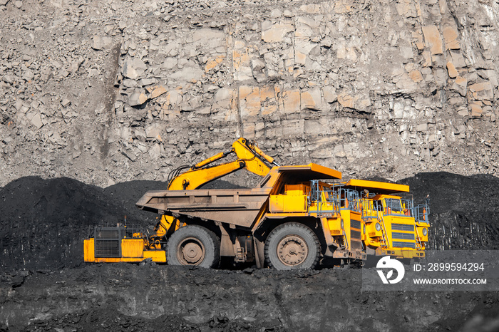 Big yellow mining truck laden anthracite moves open pit coal mine