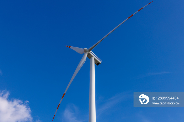 Turbina wiatrowa na tle nieba z perspektywy dolnej. Ekologiczne rozwiązania energetyczne źródeł odnawialnych.