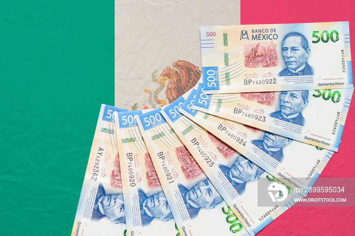 Mexican money on top of Mexican flag