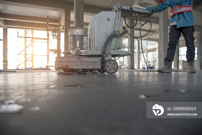 Construction worker produces the grout and finish wet concrete with a special tool. Float blades. For smoothing and polishing concrete, concrete floors