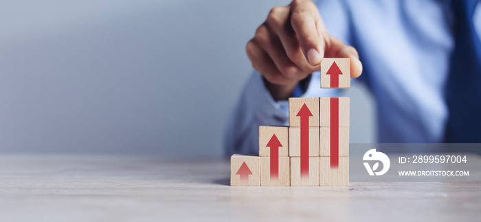 businessman hand  arranging wood block stacking as step stair with arrow up.concept for business growth success process.