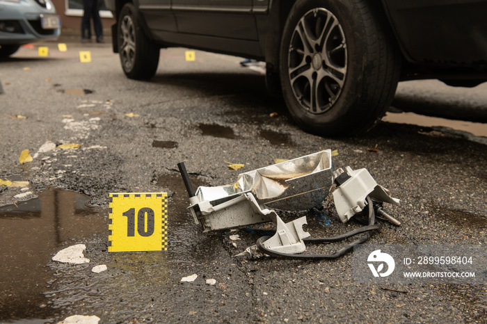 Scene of a traffic accident with car wreckage and police numbers indicating stopping distance and placement of objects, safety and traffic