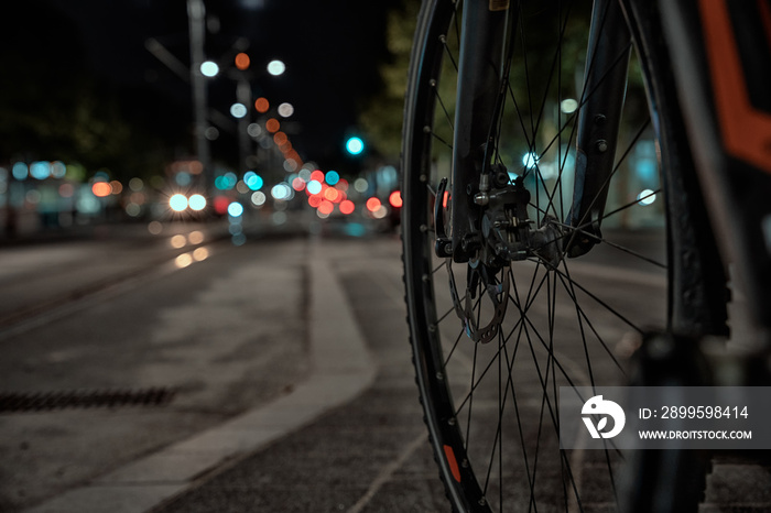 Long exposure of bicycle spokes and passing cars in a busy street in Belgrade