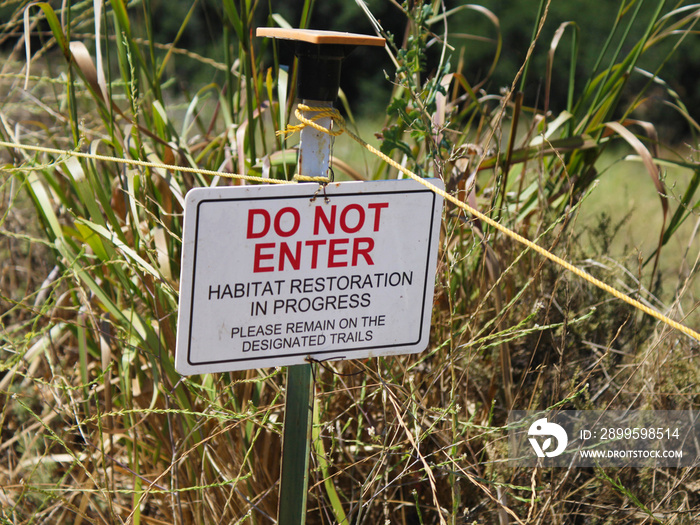 Habitat restoration sign and ropes along a trailside