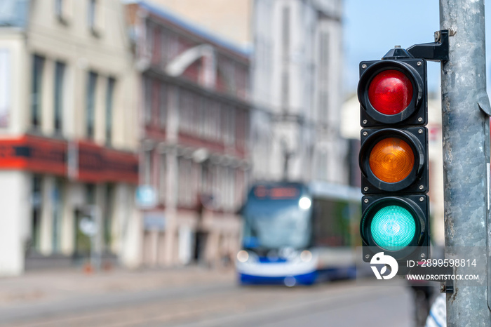 closeup of small traffic semaphore with green light against the backdrop of the city traffic