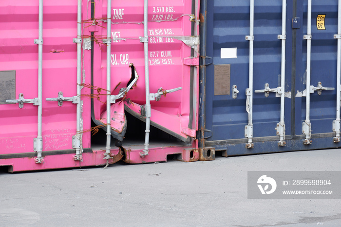 Shipping containers are stacked at the port. one of them is damaged