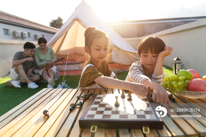 在户外露营的快乐儿童下国际象棋