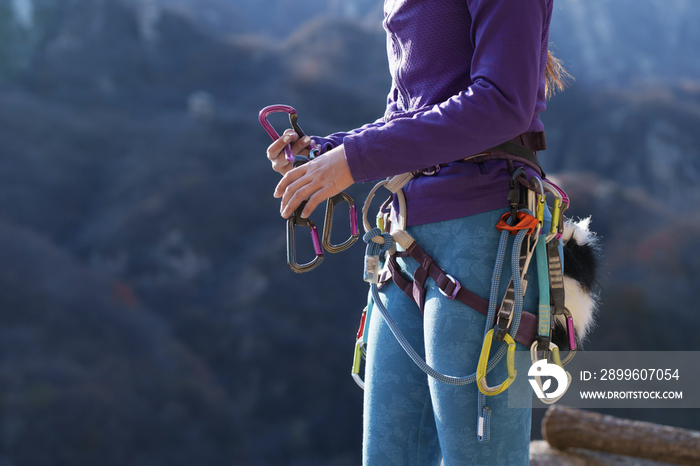 青年女性登山者调整安全设备