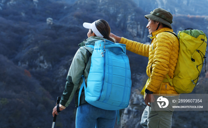 青年登山者伴侣站在山顶俯瞰