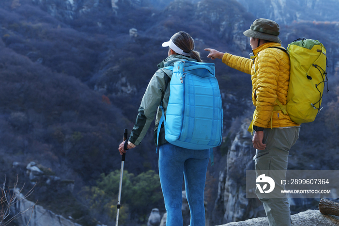 青年登山者伴侣站在山顶俯瞰