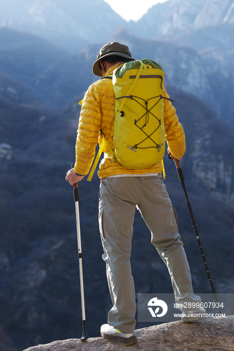 青年登山者站在山顶俯瞰