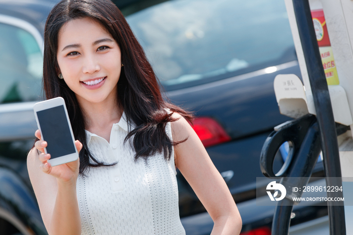 青年女人使用手机自助充电汽车