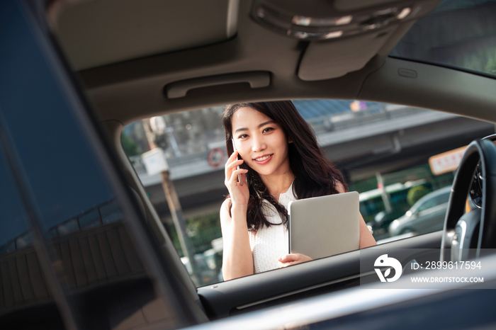 打电话的青年女人走向汽车