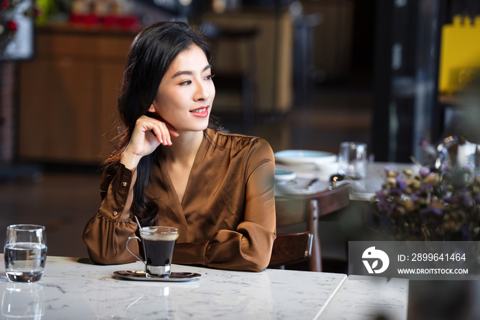 漂亮的青年女人喝咖啡