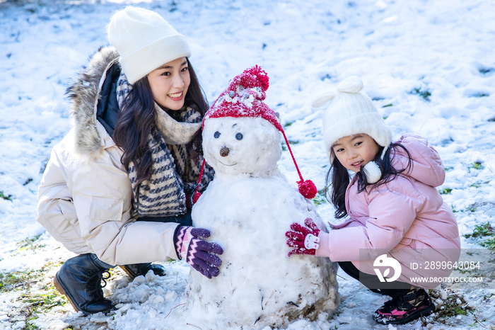 快乐的母女推雪人