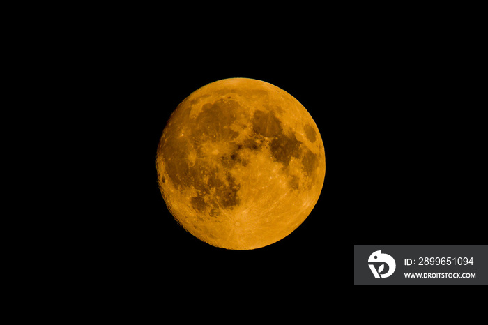 Closeup shot of the golden moon at the midpoint of a black background