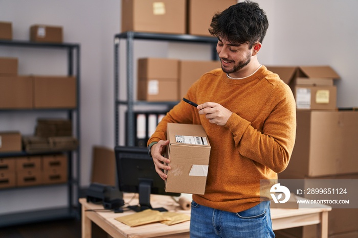 Young hispanic man ecommerce business worker scanning package at office