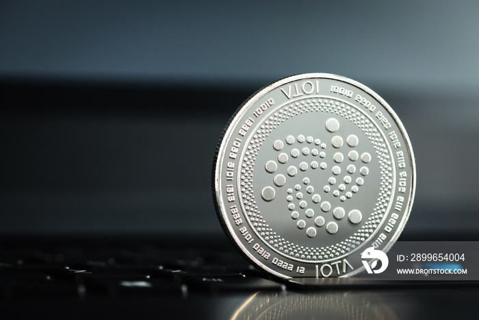 Crypto currency coin - IOTA on dark laptop keyboard