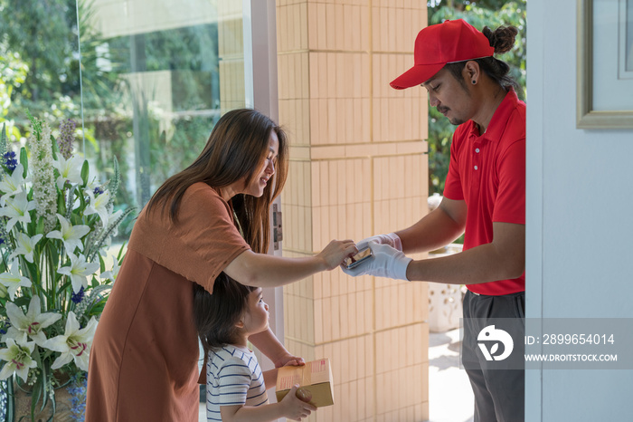 The safe delivery concept, Mother and little daughter opened the door to pick the parcel from the co