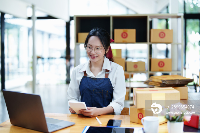 Starting small business entrepreneur of independent Asian woman smiling using computer laptop with c