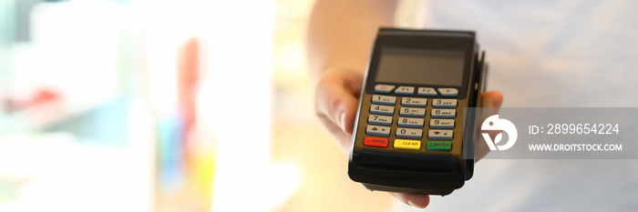 Close-up of delivery service male holding cashier machine for fast payment. Nfc technology counter. 