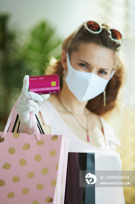 woman shopper with mask, rubber gloves, credit card and bags